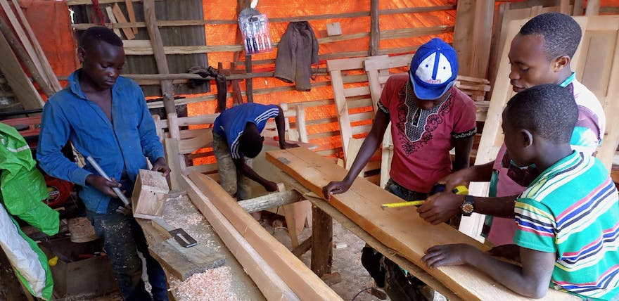 Een groep jongeren in een hout workshop.
