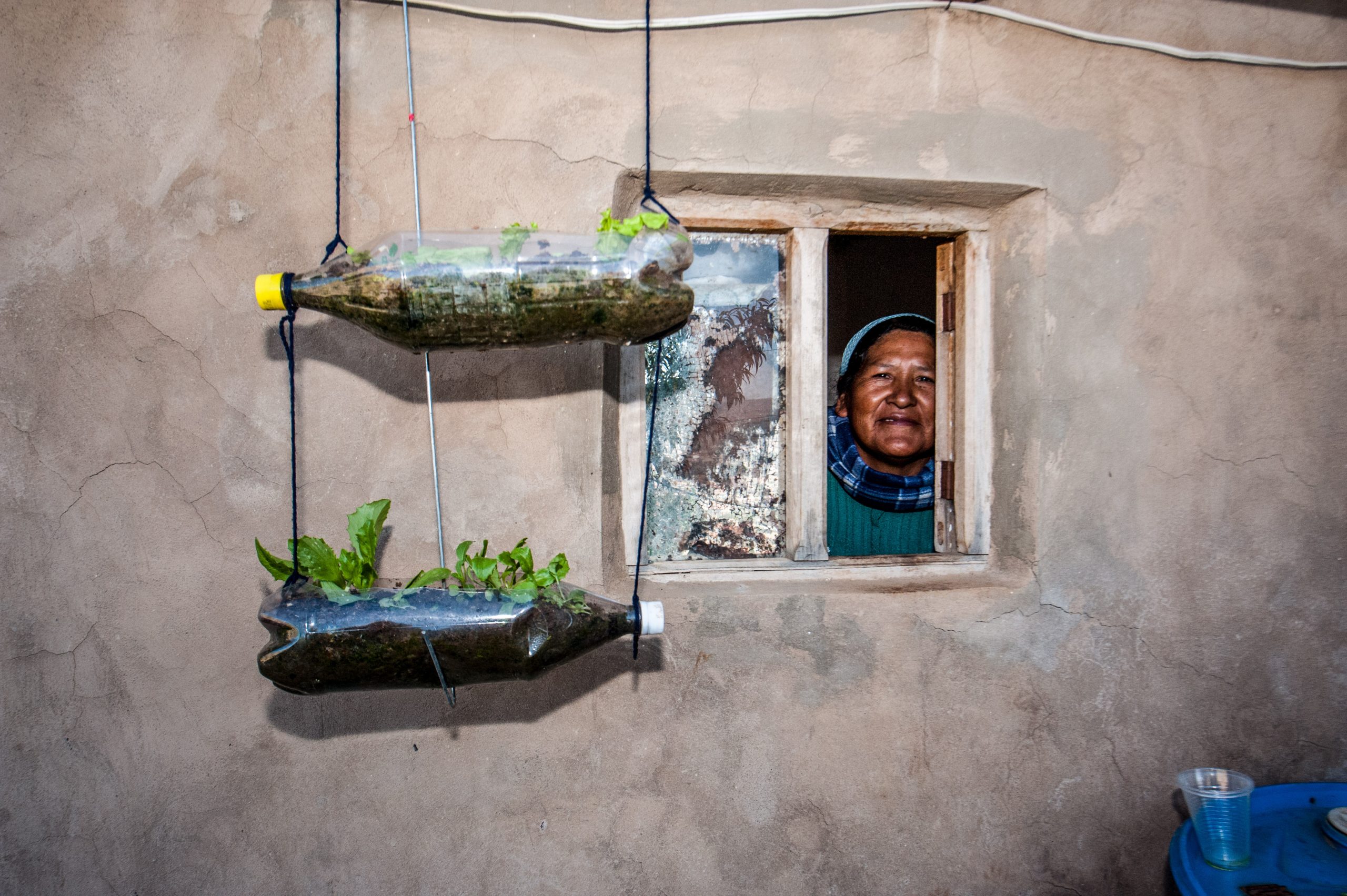 Een vrouw kijkt uit haar raam in Armenië