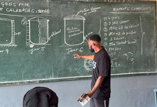 Een man in Congo geeft uitleg hoe watertanks gebouwd moeten worden