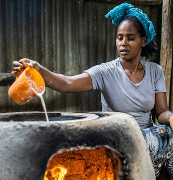 Vrouw bakt platbrood in een traditionele oven in Ethiopië