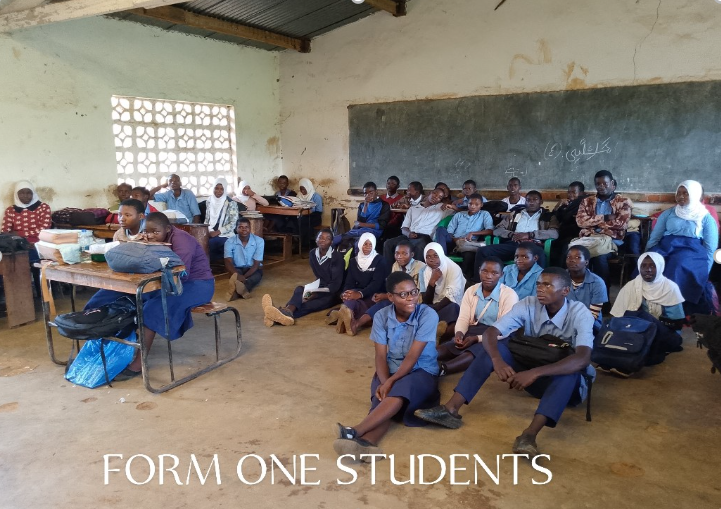 Een groep studenten zit op de grond in een klaslokaal
