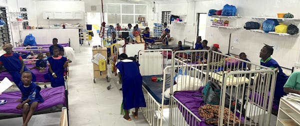 Een ziekenhuisafdeling met witte bedden en patienten