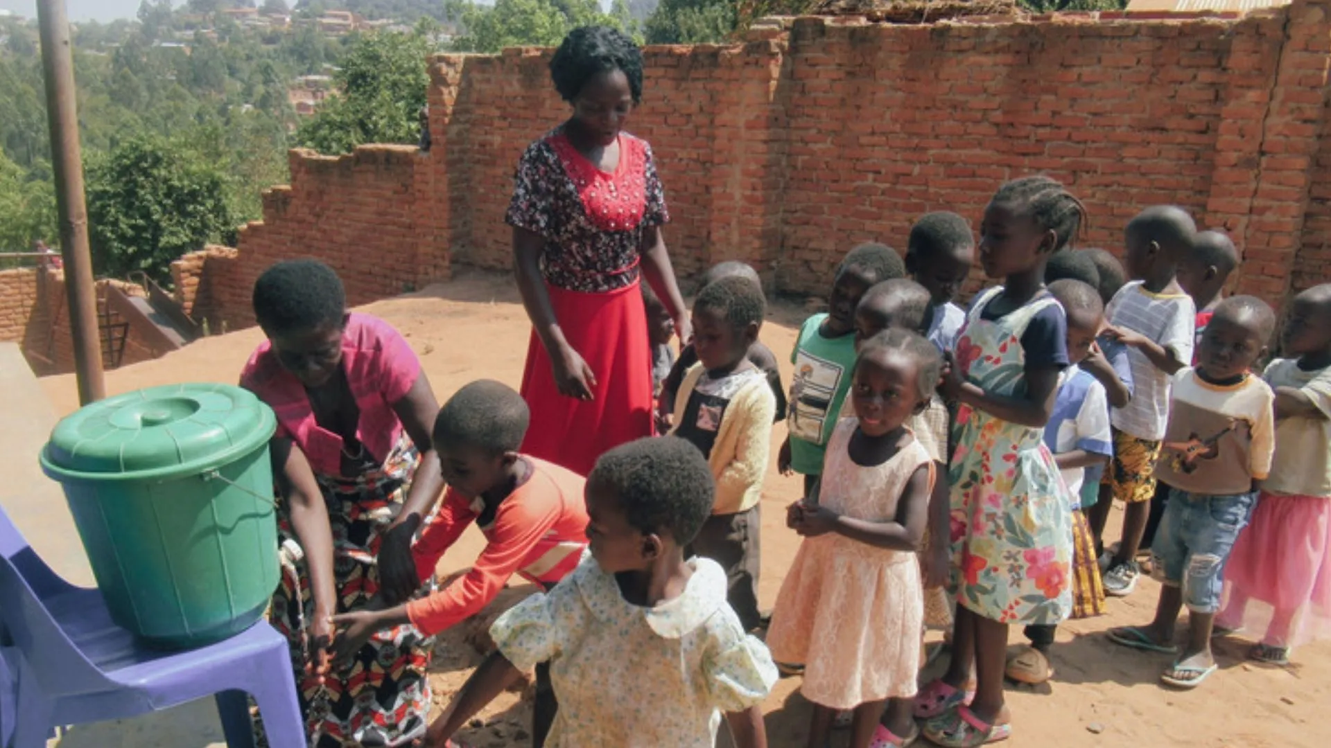 Een groep kinderen was hun handen op een schoolplein.