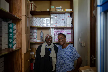 Twee vrouwen staan in een kast met medicijnen.